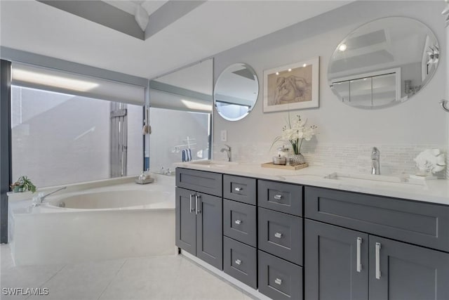 bathroom with tile patterned flooring, vanity, a bathing tub, and backsplash