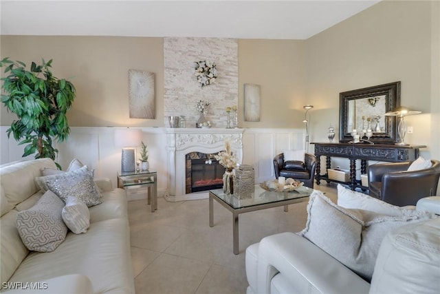 living room with a large fireplace and light tile patterned floors