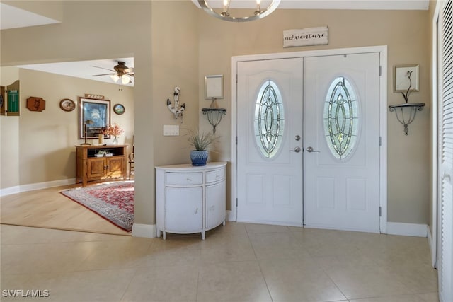 foyer with ceiling fan with notable chandelier and light hardwood / wood-style floors