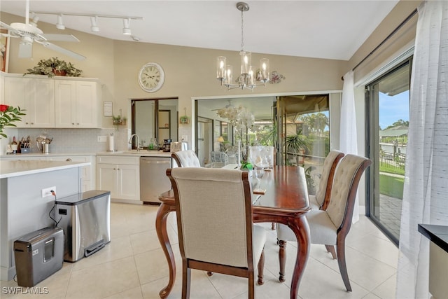 tiled dining area with sink, ceiling fan with notable chandelier, and lofted ceiling