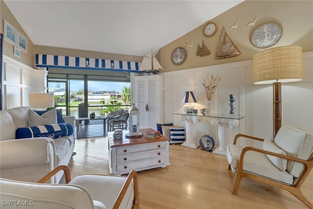 living room featuring light hardwood / wood-style floors and vaulted ceiling