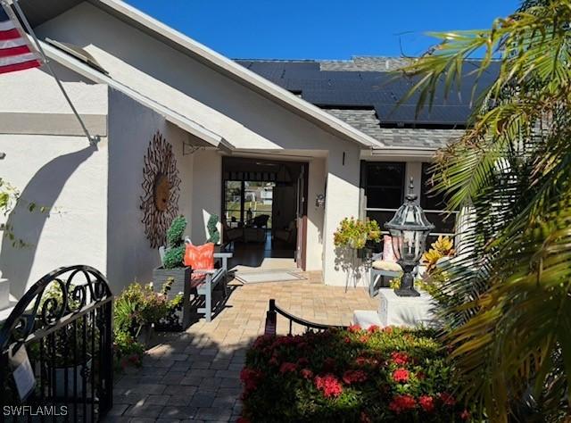 entrance to property featuring a patio area and solar panels