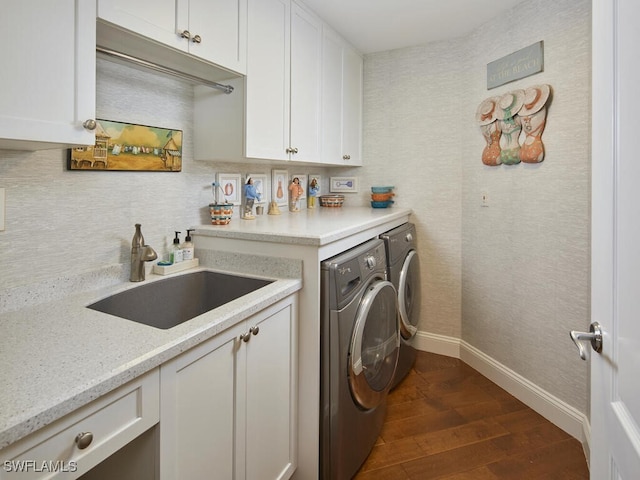 laundry room with washing machine and dryer, cabinets, sink, and dark wood-type flooring