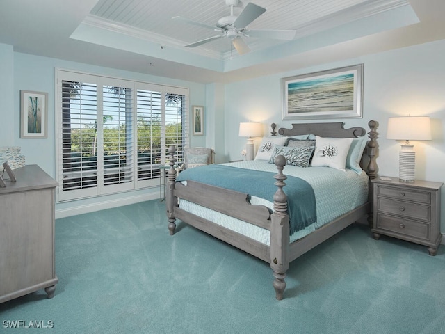 carpeted bedroom with ceiling fan, crown molding, and a tray ceiling