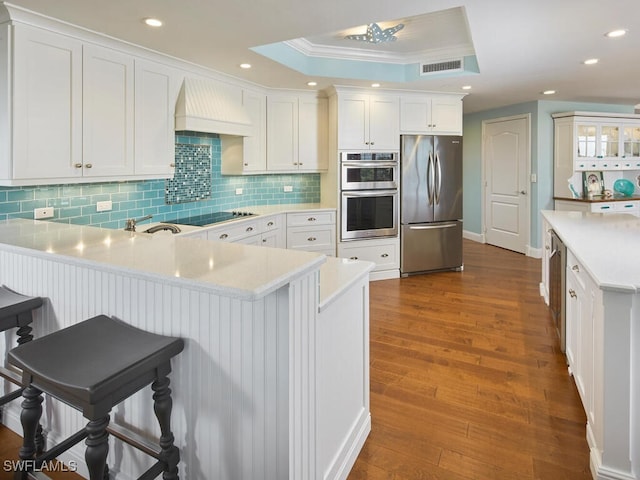 kitchen with white cabinets, custom range hood, stainless steel appliances, and dark hardwood / wood-style floors