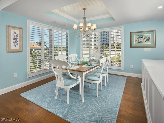 dining area with a raised ceiling, dark hardwood / wood-style flooring, and plenty of natural light