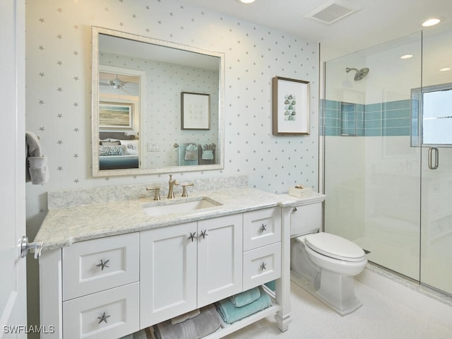 bathroom with vanity, toilet, and a shower with door