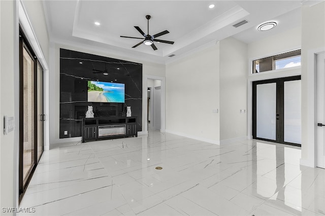 unfurnished living room with french doors, a raised ceiling, ceiling fan, and ornamental molding