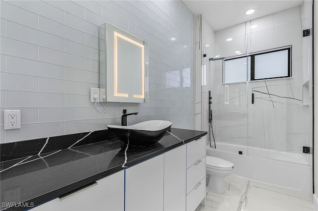 full bathroom with vanity, toilet, enclosed tub / shower combo, and tile walls