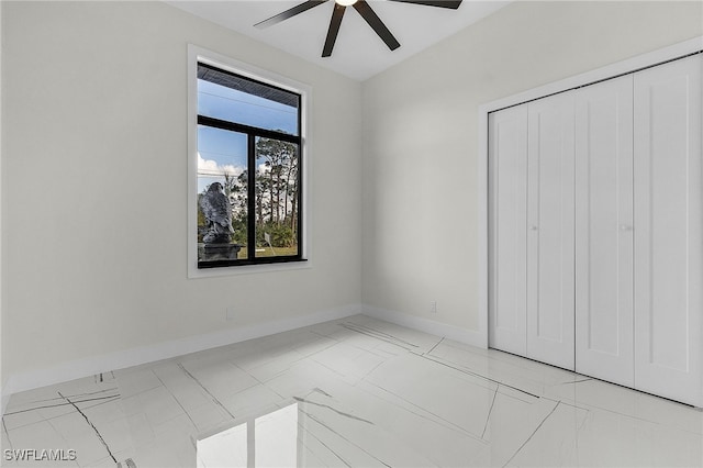 unfurnished bedroom with ceiling fan and a closet