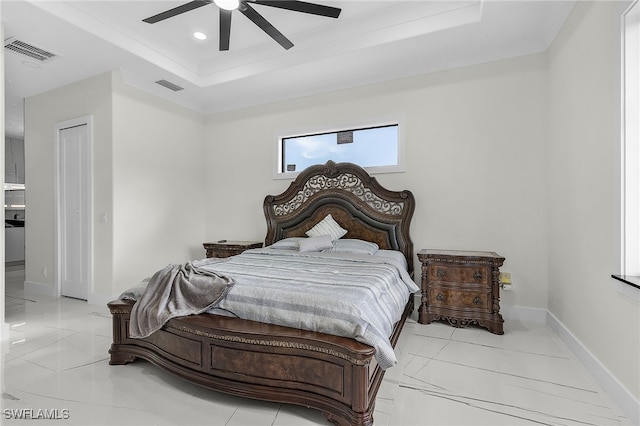 bedroom with a tray ceiling and ceiling fan