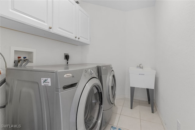 laundry room with cabinets, separate washer and dryer, and light tile patterned floors