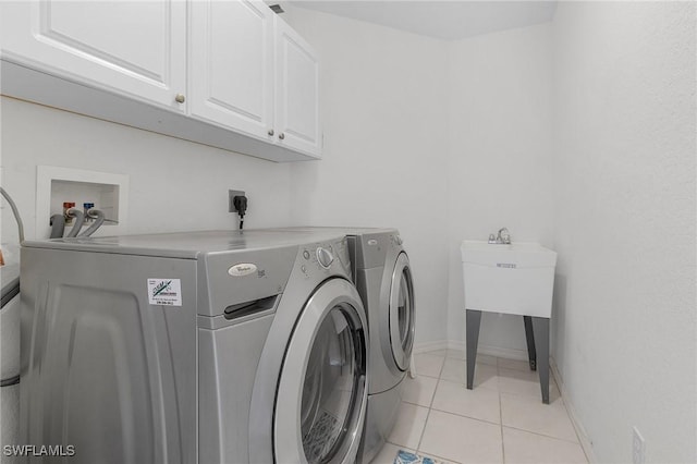 2819 SW 37th Ter, Cape Coral, FL 33914 - washroom with cabinet space, washing machine and dryer, light tile patterned floors, and baseboards
