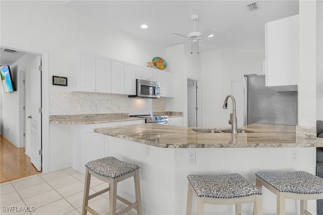 kitchen featuring white cabinetry, sink, kitchen peninsula, and stainless steel appliances