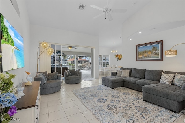 tiled living room featuring ceiling fan and a high ceiling