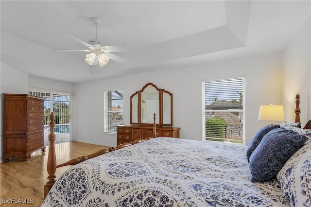 bedroom with access to outside, light hardwood / wood-style flooring, multiple windows, and ceiling fan