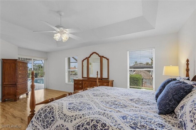 2819 SW 37th Ter, Cape Coral, FL 33914 - bedroom featuring light wood-style flooring, access to exterior, ceiling fan, and a tray ceiling