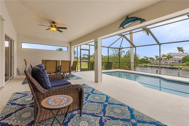 view of swimming pool with a patio, a water view, ceiling fan, and a lanai