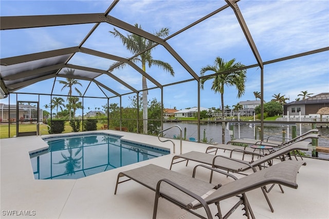 view of swimming pool featuring glass enclosure, a patio area, and a water view