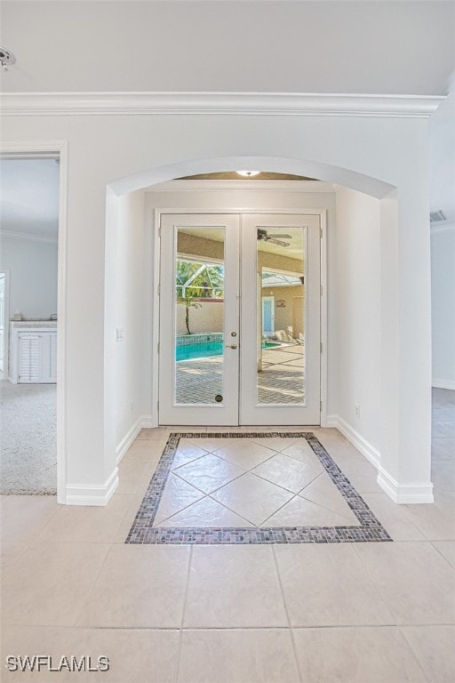 doorway with light tile patterned flooring, lofted ceiling, crown molding, and french doors