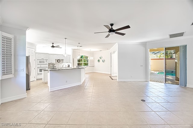 kitchen with white cabinets, a healthy amount of sunlight, white appliances, and crown molding