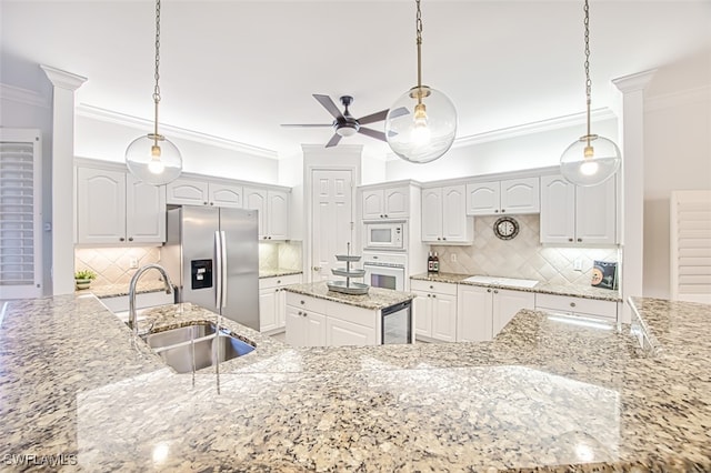 kitchen with backsplash, white cabinets, hanging light fixtures, and white appliances