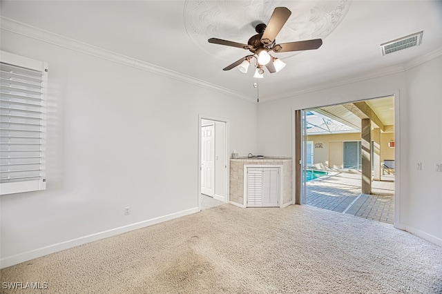 carpeted spare room featuring ceiling fan and ornamental molding