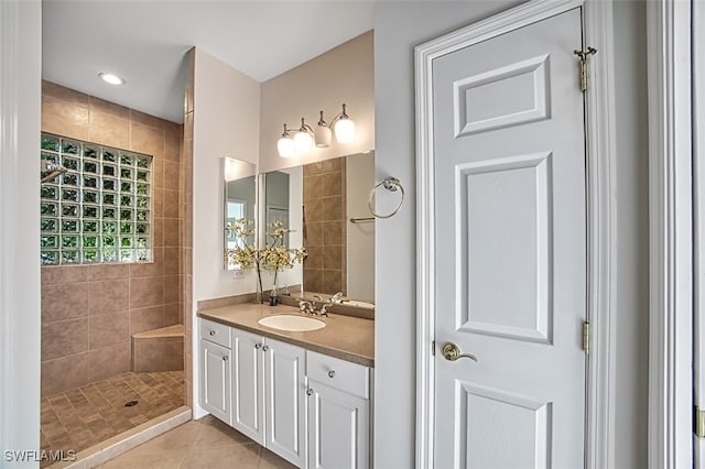 bathroom featuring tile patterned floors, vanity, and a tile shower