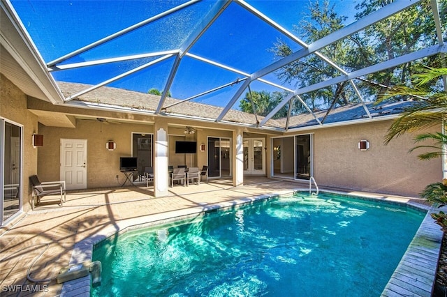 view of swimming pool featuring ceiling fan, a patio area, and a lanai