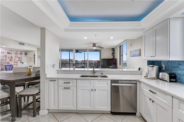 kitchen featuring backsplash, white cabinets, sink, stainless steel dishwasher, and light tile patterned floors