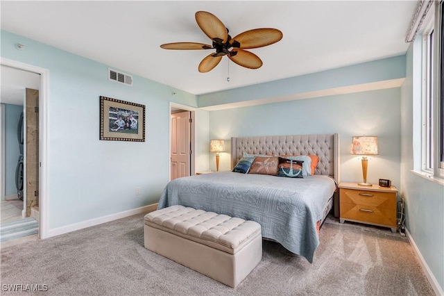 carpeted bedroom with ensuite bathroom and ceiling fan