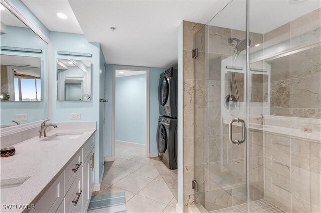 bathroom featuring vanity, tile patterned floors, a shower with shower door, and stacked washer / drying machine