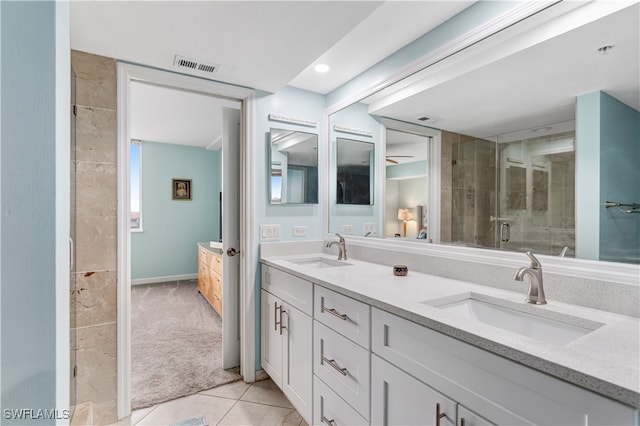 bathroom featuring tile patterned floors, vanity, and a shower with shower door