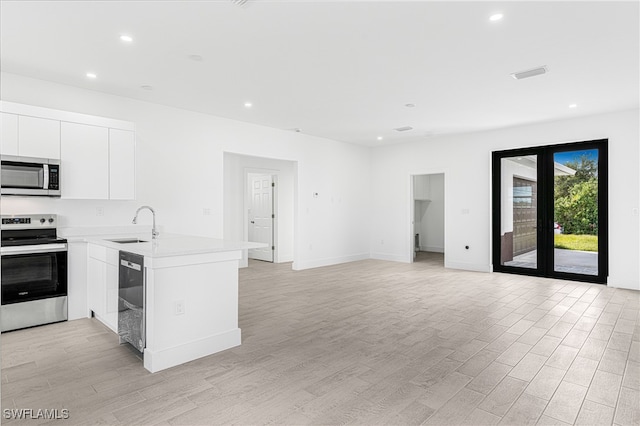 kitchen featuring white cabinetry, sink, kitchen peninsula, appliances with stainless steel finishes, and light wood-type flooring