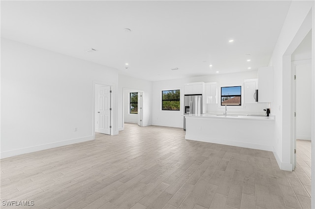 unfurnished living room featuring light hardwood / wood-style floors and sink