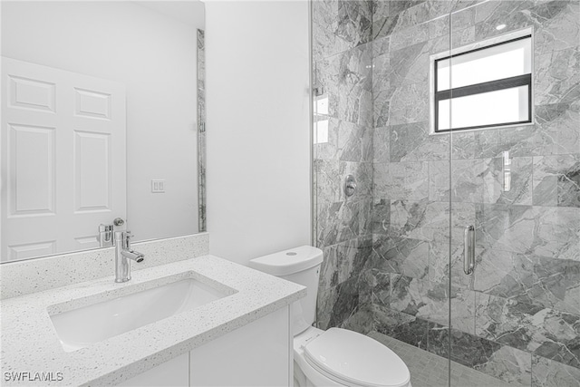 bathroom featuring vanity, toilet, and a shower with shower door