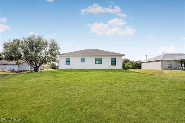 rear view of house featuring a yard