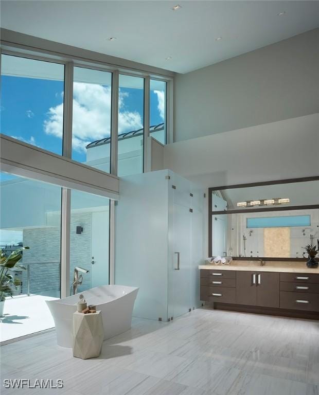 27804 Hickory Blvd, Bonita Springs, FL 34134 - full bathroom featuring vanity, a soaking tub, a shower stall, and a towering ceiling