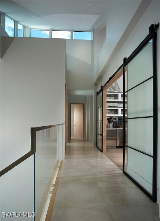 27804 Hickory Blvd, Bonita Springs, FL 34134 - hallway featuring a barn door and a high ceiling