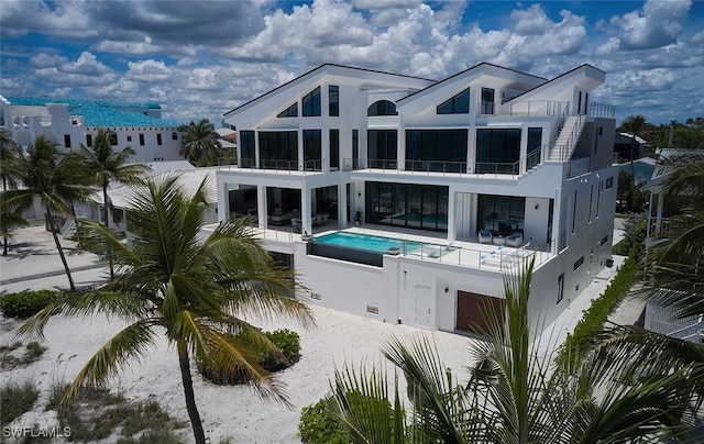 27804 Hickory Blvd, Bonita Springs, FL 34134 - back of property featuring an outdoor pool, a sunroom, a balcony, and stucco siding