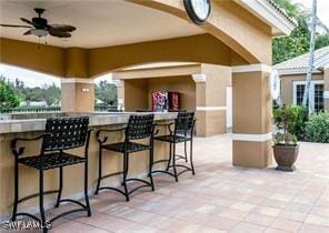 view of patio with a bar and ceiling fan