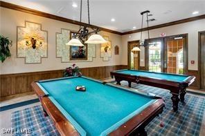 recreation room featuring wood walls, crown molding, and pool table