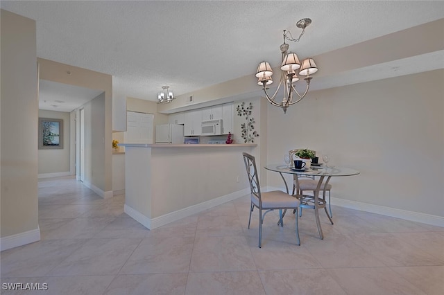 dining area featuring light tile patterned floors, a textured ceiling, and a chandelier