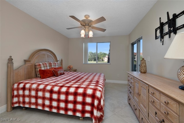 tiled bedroom featuring a textured ceiling and ceiling fan