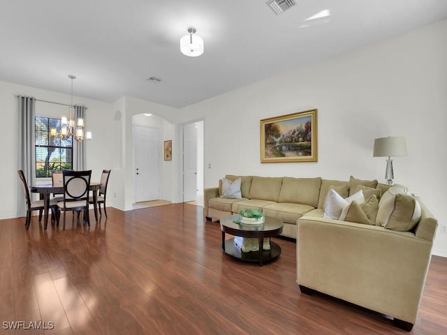 living room featuring a chandelier and dark hardwood / wood-style floors