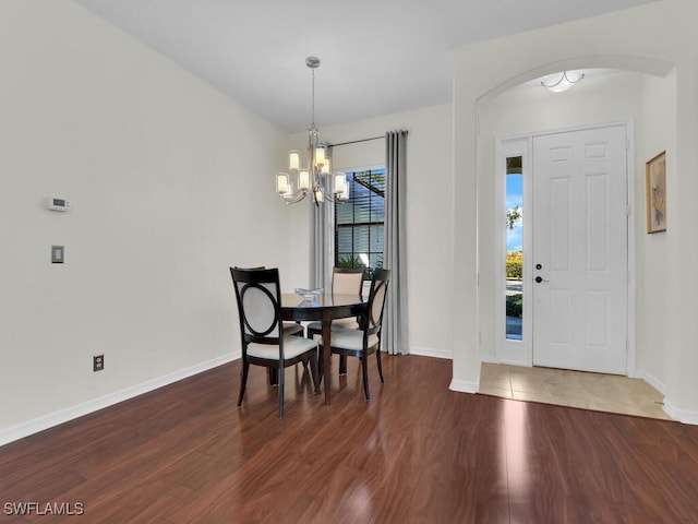 dining space featuring dark hardwood / wood-style floors and an inviting chandelier