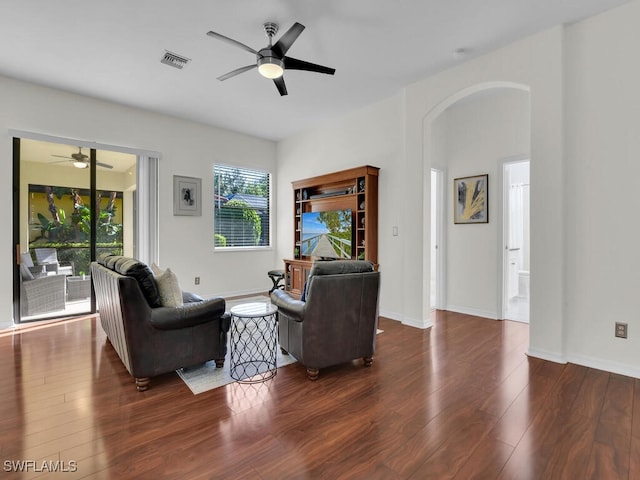 living room with ceiling fan and dark hardwood / wood-style flooring