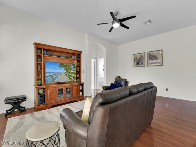 living room featuring ceiling fan and dark wood-type flooring