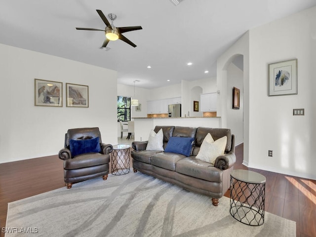 living room featuring ceiling fan, sink, and hardwood / wood-style flooring