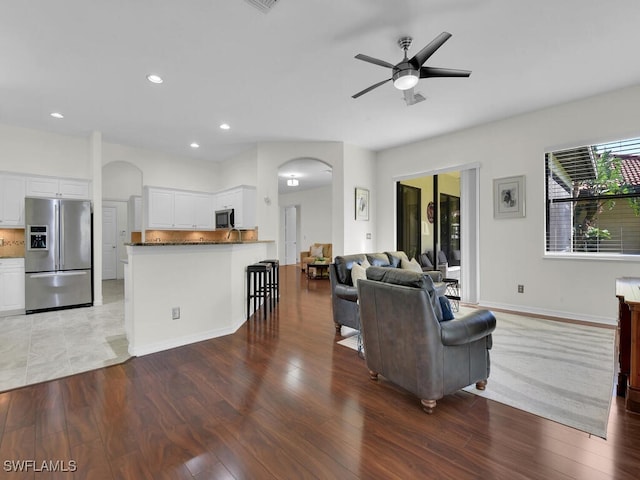 living room featuring ceiling fan and hardwood / wood-style flooring